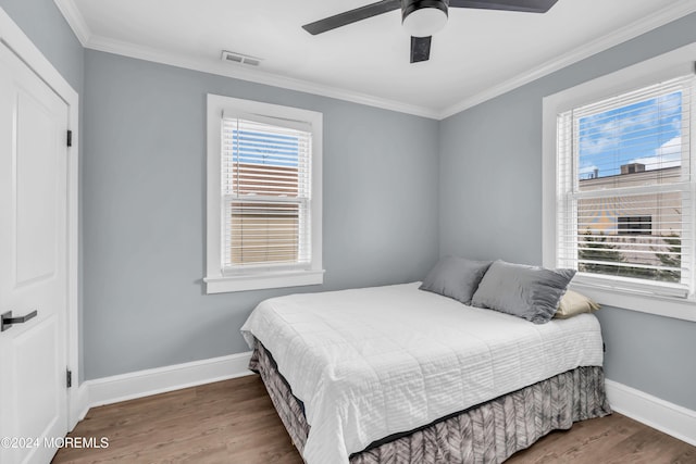 bedroom with wood-type flooring, ceiling fan, and crown molding