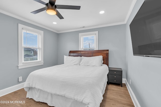 bedroom with multiple windows, light hardwood / wood-style floors, ceiling fan, and crown molding