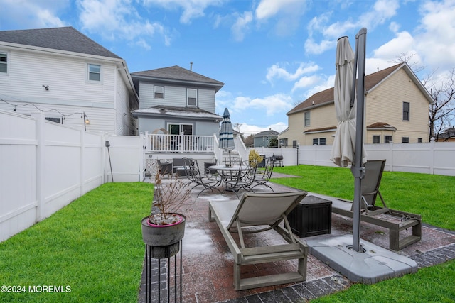 back of property featuring a yard, a patio, and a deck