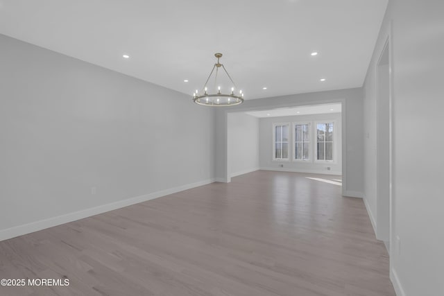 spare room with a chandelier and light hardwood / wood-style flooring