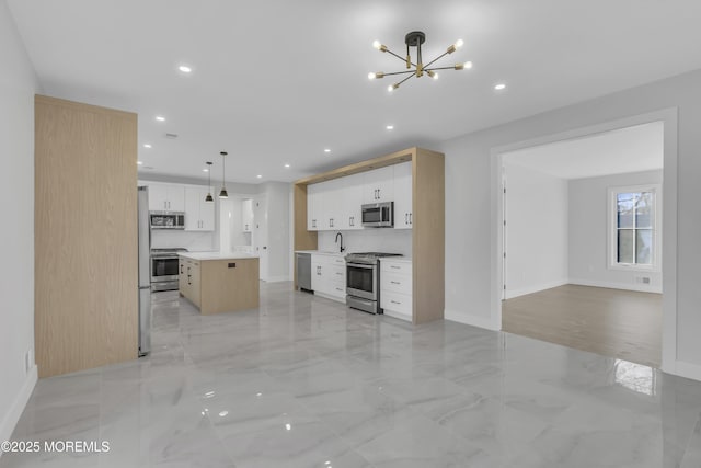 kitchen featuring white cabinetry, pendant lighting, a center island, and stainless steel appliances