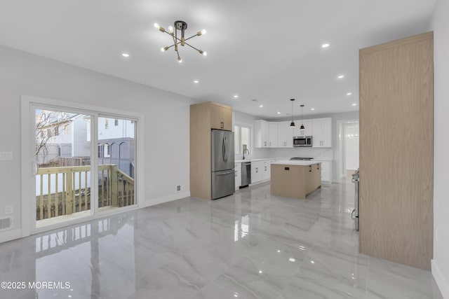 kitchen with white cabinetry, a center island, hanging light fixtures, stainless steel appliances, and an inviting chandelier