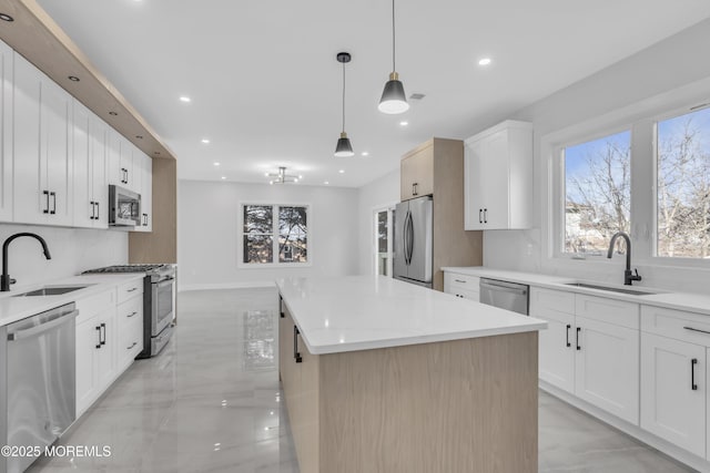 kitchen featuring white cabinets, appliances with stainless steel finishes, and sink