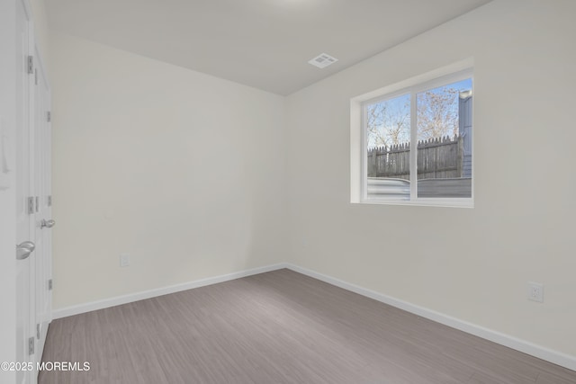 unfurnished room with hardwood / wood-style flooring