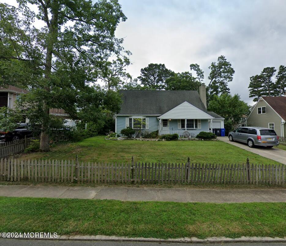 view of front of property featuring a front yard, a porch, and a garage