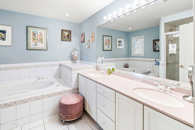 bathroom with a stall shower, a sink, a bath, and tile patterned floors