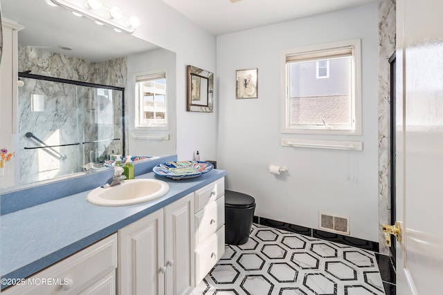 bathroom with visible vents, toilet, vanity, and a marble finish shower