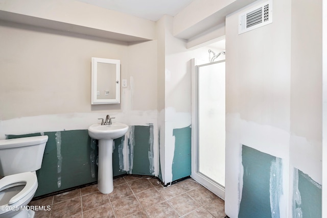 full bath featuring tile patterned flooring, toilet, a sink, visible vents, and a shower stall