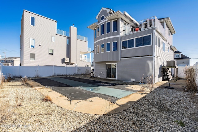 rear view of property featuring a patio area, fence, and central air condition unit