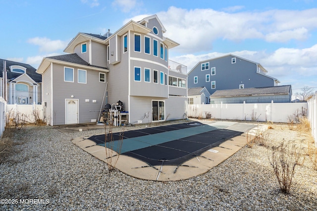 rear view of house with a patio area, a fenced backyard, and a fenced in pool