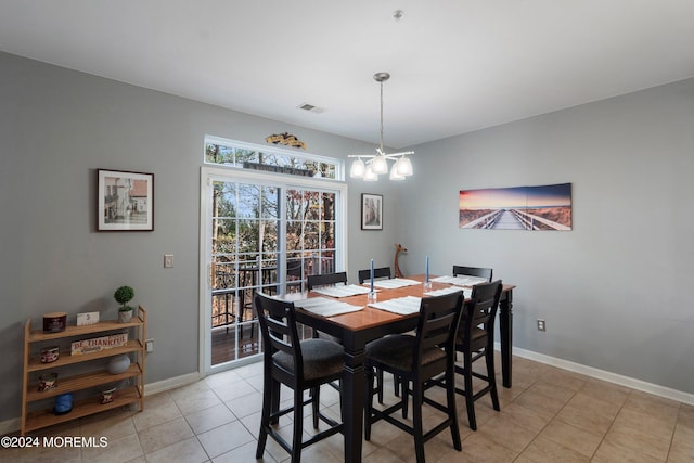 dining room featuring a notable chandelier and light tile patterned flooring