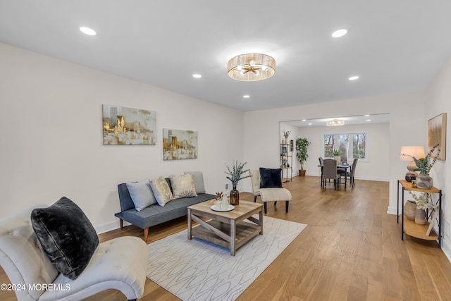 living room with light hardwood / wood-style flooring and a notable chandelier