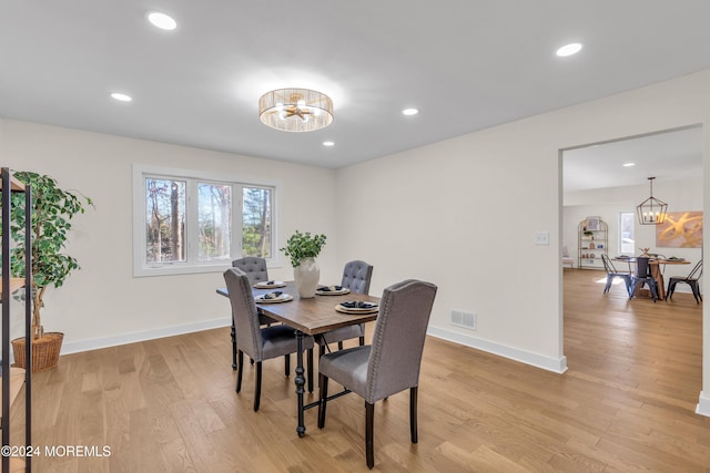 dining area featuring light wood-type flooring and an inviting chandelier