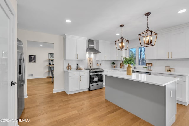 kitchen with white cabinets, stainless steel appliances, and wall chimney range hood