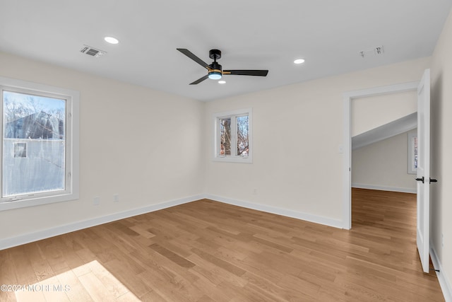 spare room featuring a healthy amount of sunlight, ceiling fan, and light hardwood / wood-style floors