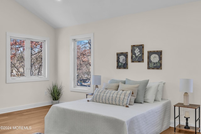 bedroom featuring wood-type flooring and vaulted ceiling