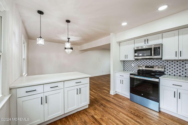 kitchen featuring white cabinets, decorative light fixtures, stainless steel appliances, and tasteful backsplash