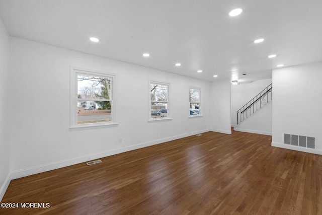 unfurnished living room with dark hardwood / wood-style floors and a wealth of natural light