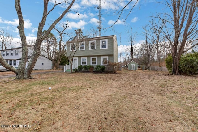 view of front of property featuring a shed and a front lawn