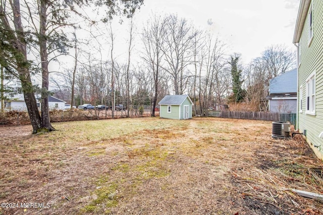 view of yard featuring a storage unit and central AC