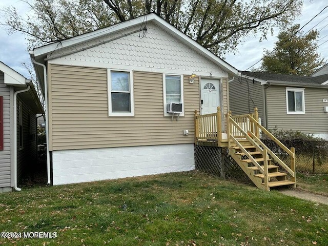 view of front of home with cooling unit and a front yard