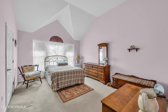 bedroom with high vaulted ceiling and light colored carpet