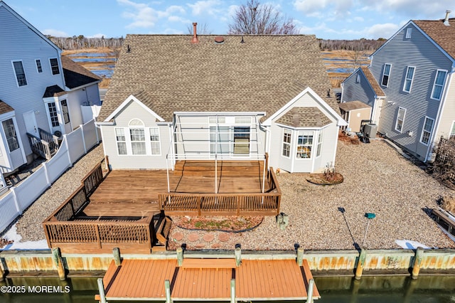 back of house with a deck with water view and a shed