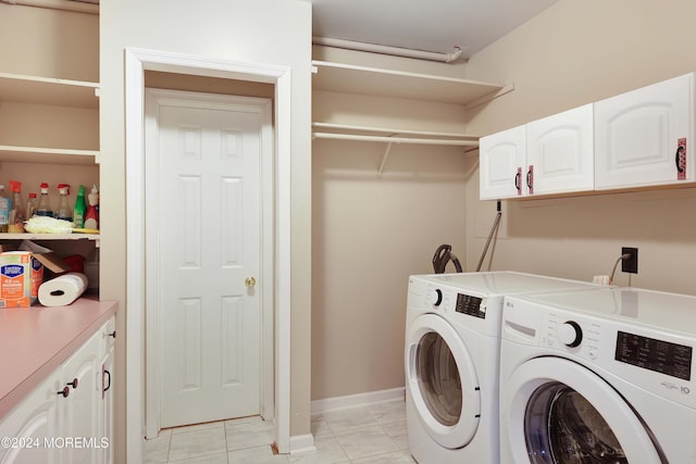 laundry room featuring washer and dryer and cabinets