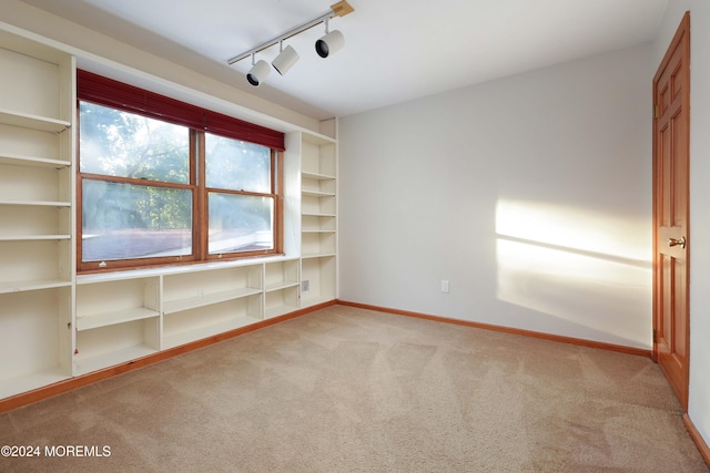 unfurnished room with light carpet and rail lighting