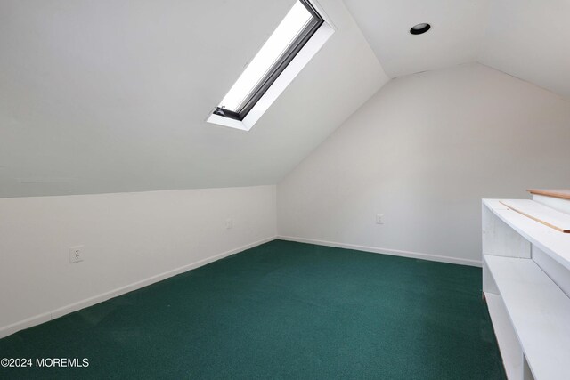 additional living space with carpet flooring and vaulted ceiling with skylight