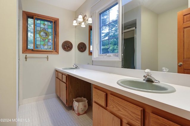 bathroom with vanity, tile patterned floors, a shower with door, and a healthy amount of sunlight