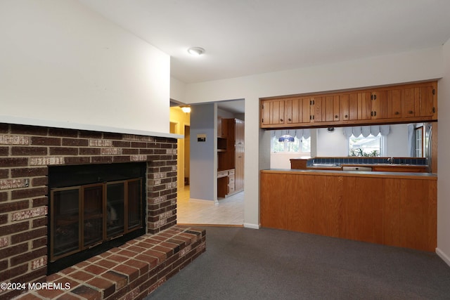 kitchen featuring carpet flooring and a brick fireplace