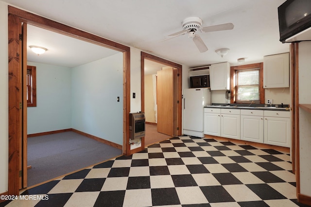 kitchen featuring heating unit, ceiling fan, white cabinets, and white fridge