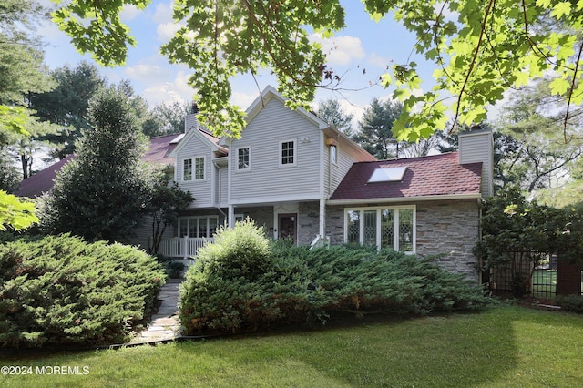 rear view of house featuring a lawn