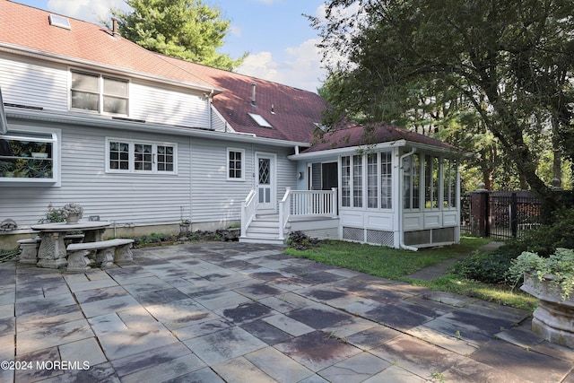 rear view of property with a patio and a sunroom