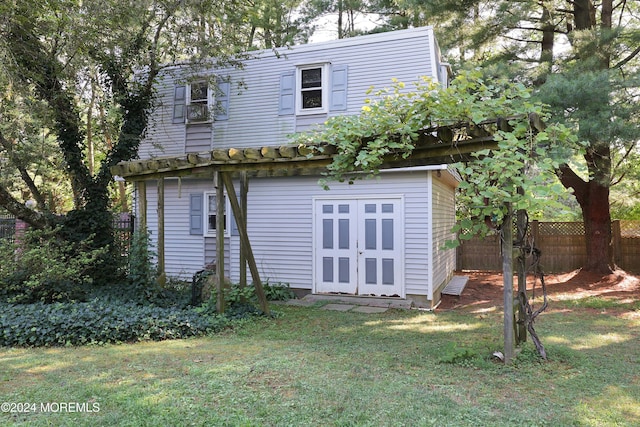 rear view of house featuring a lawn and an outdoor structure