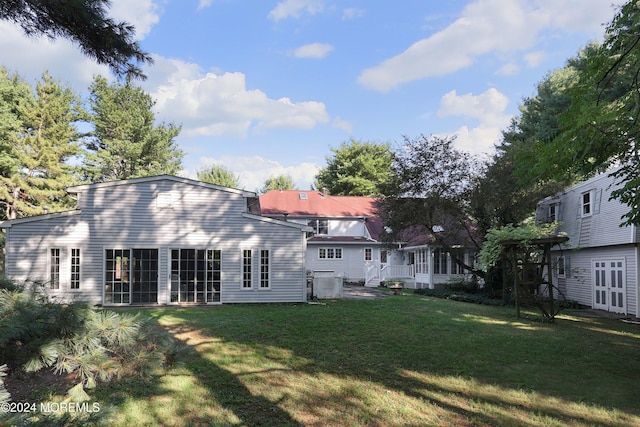 rear view of property featuring a lawn