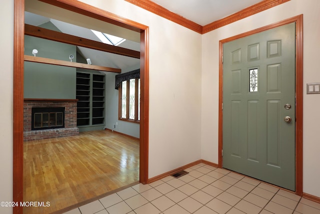 tiled entryway featuring a brick fireplace and vaulted ceiling