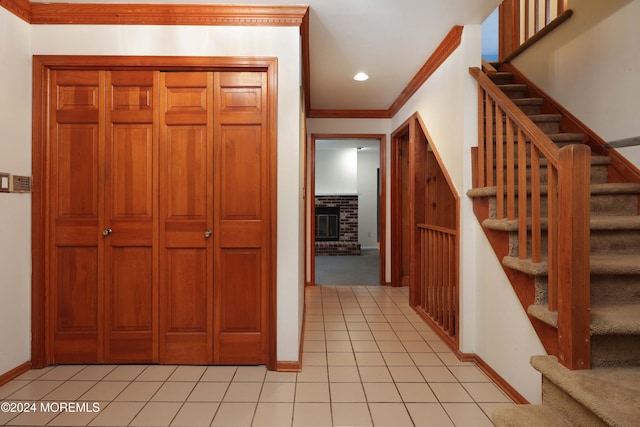 interior space with a fireplace, crown molding, and light tile patterned flooring