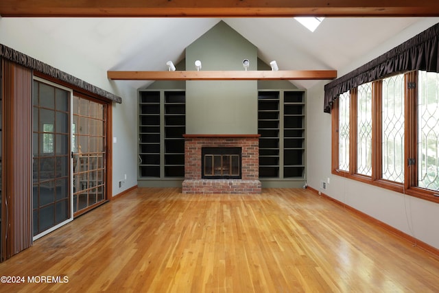 unfurnished living room featuring hardwood / wood-style floors, a brick fireplace, and lofted ceiling