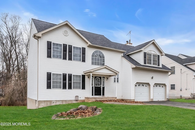 view of front of home with a garage and a front lawn