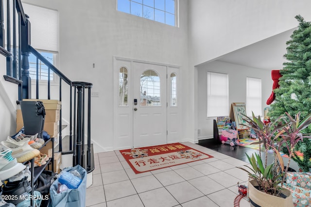 foyer featuring light tile patterned floors and a towering ceiling