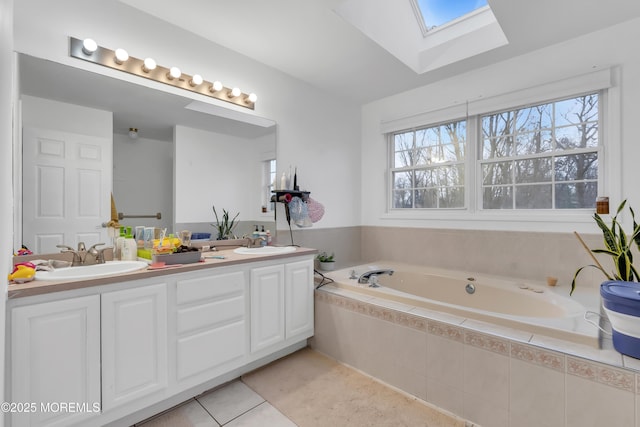 bathroom with tile patterned floors, vanity, a wealth of natural light, and a skylight