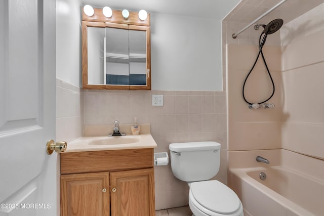 full bathroom featuring vanity, bathing tub / shower combination, toilet, and tile walls