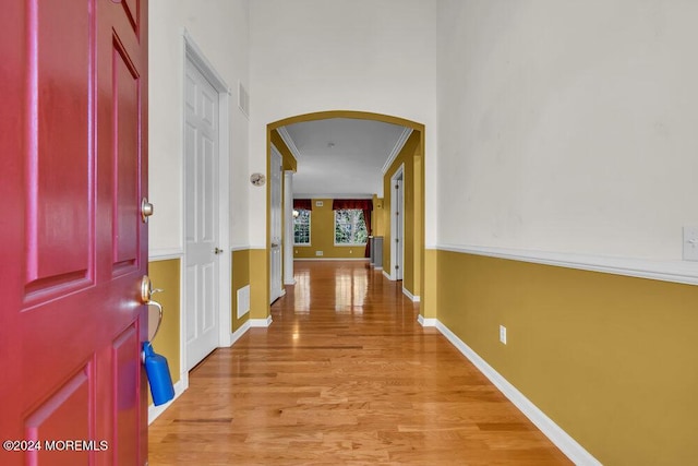 hallway featuring light hardwood / wood-style floors and ornamental molding