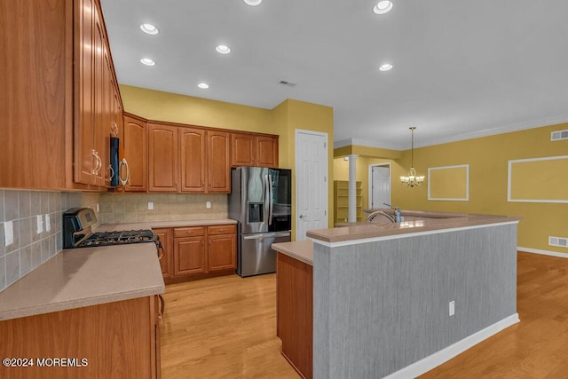 kitchen with light wood-type flooring, stainless steel refrigerator with ice dispenser, stove, and a center island with sink