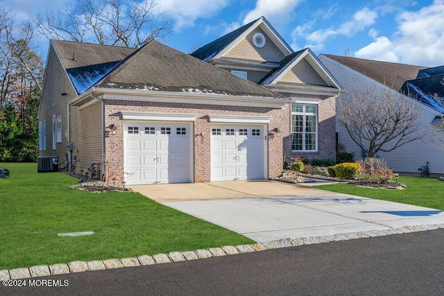 view of property featuring a garage, central air condition unit, and a front lawn