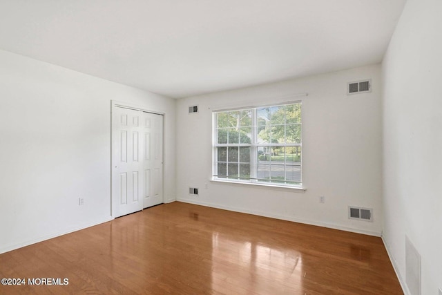 unfurnished bedroom with hardwood / wood-style flooring and a closet