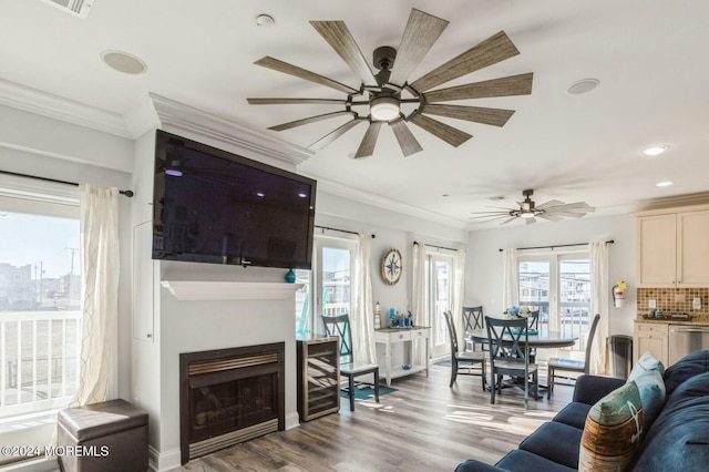 living room featuring ceiling fan, light hardwood / wood-style floors, and ornamental molding