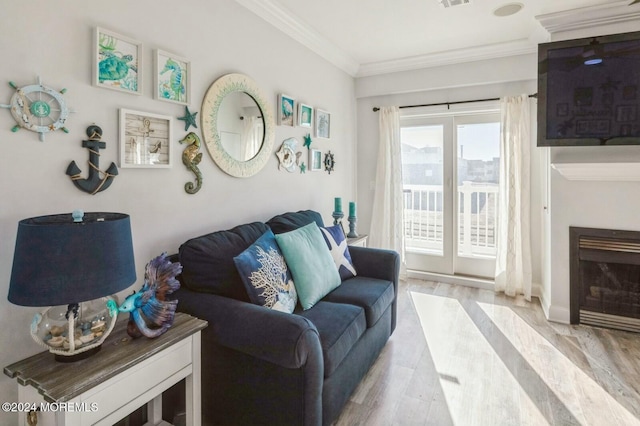 living room featuring ornamental molding and light wood-type flooring